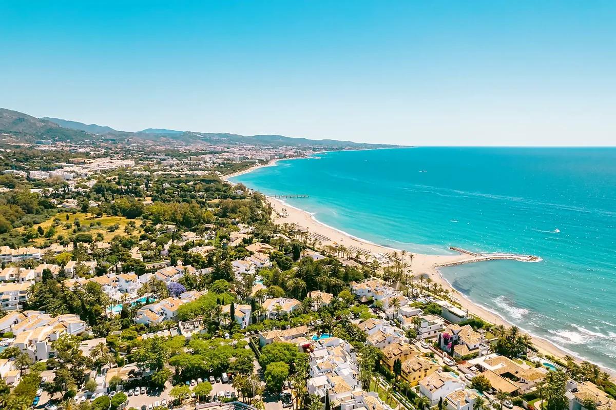 Green Costa del Sol coastline with a long beach and turquoise sea