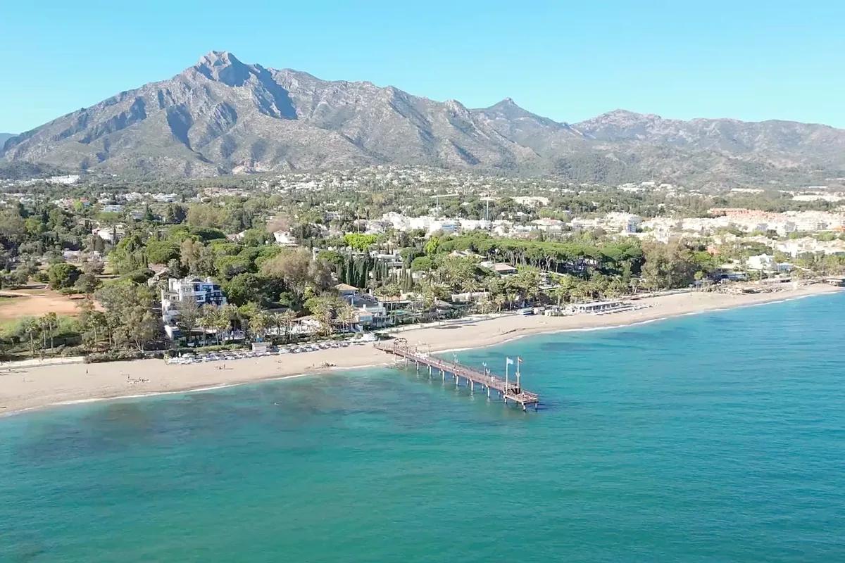 Beach and pier in Marbella below La Concha mountain