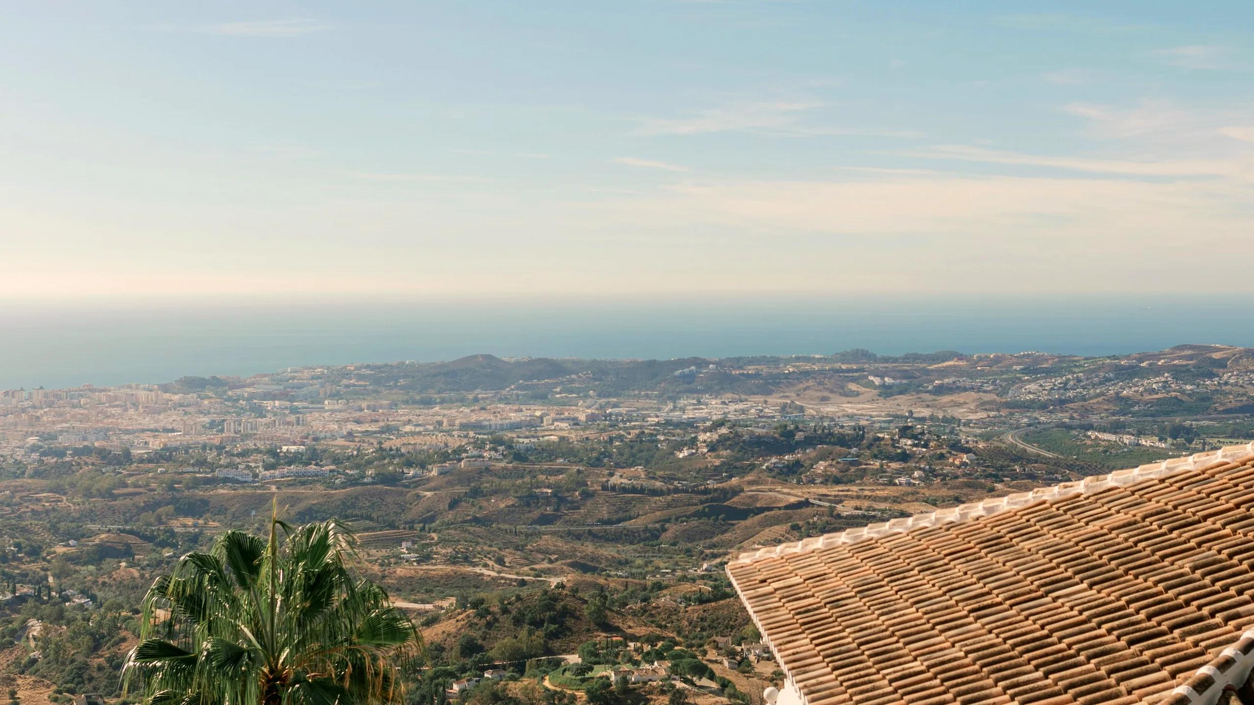 View from a villa over the rooftops of a coastal town to the sea
