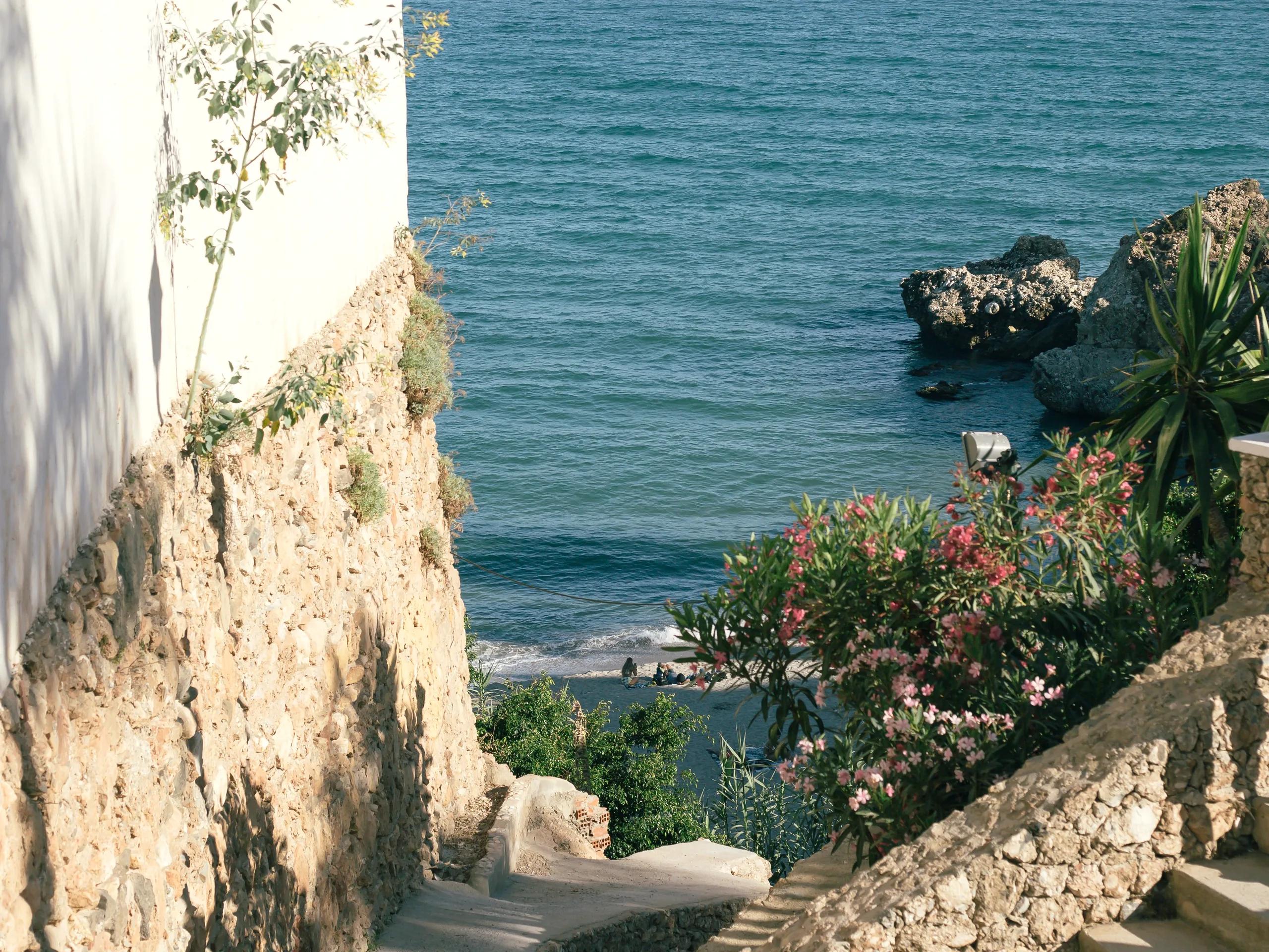 Stone steps down to a cove lined with oleanders on the Costa del Sol
