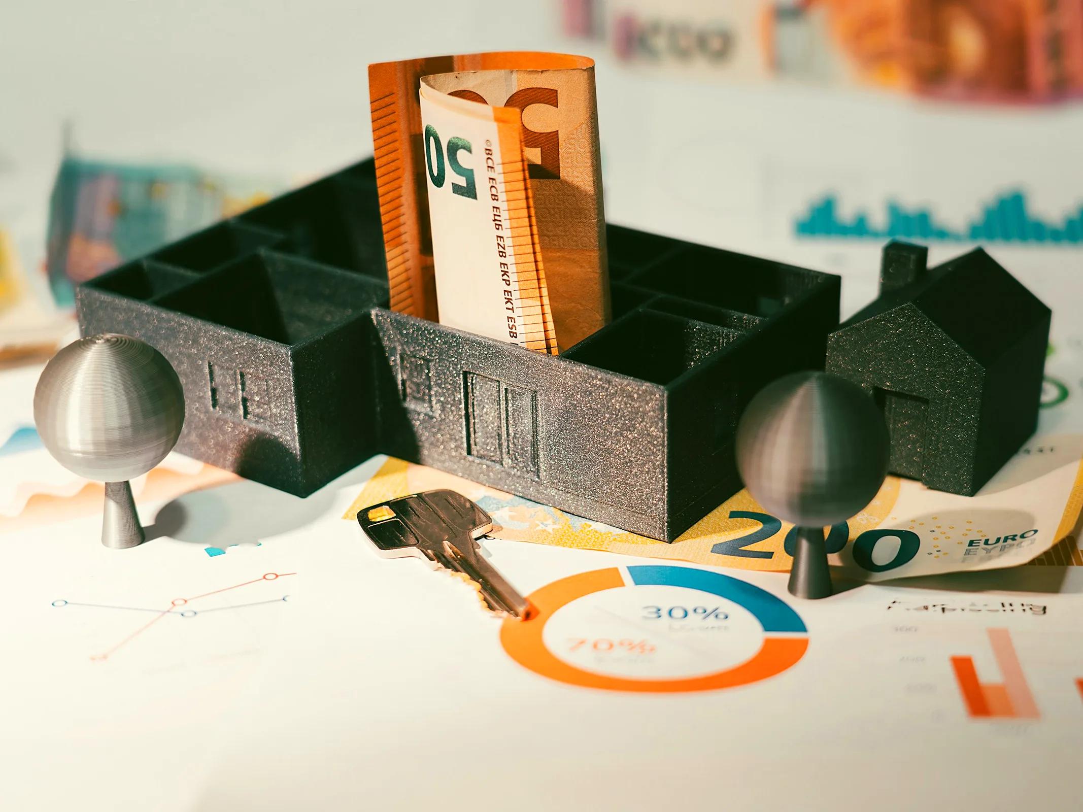 Model house with euro banknotes and a key