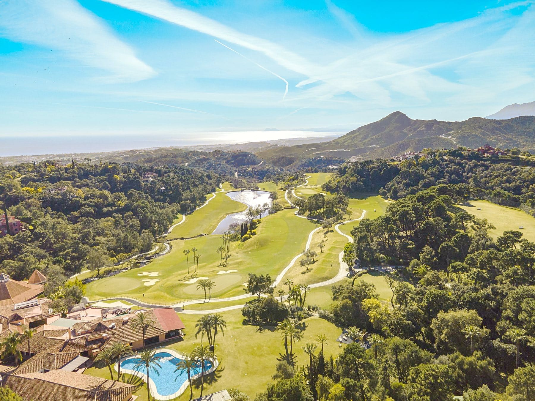 Green golf valley in Benahavís with the sea in the distance