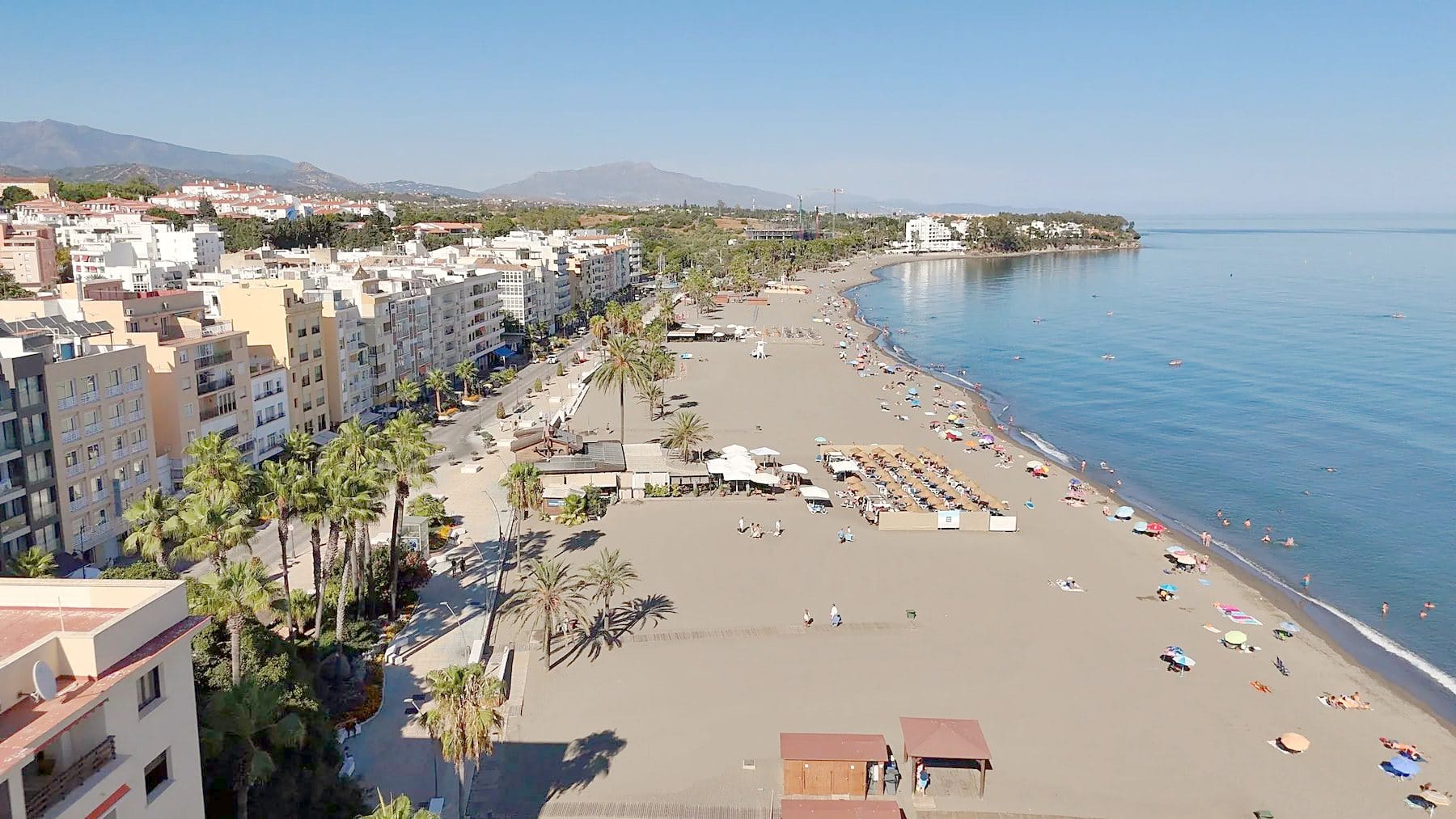 Estepona's beach and promenade with palm trees and white houses