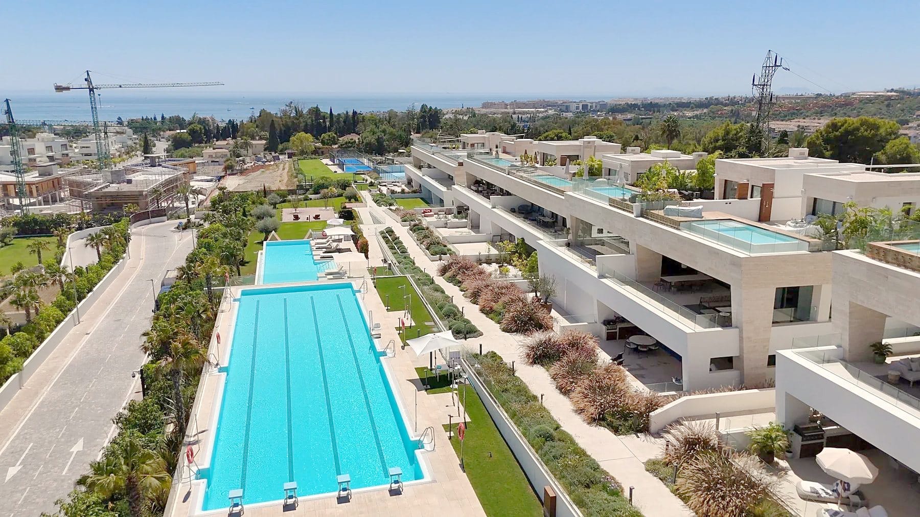 New apartment buildings with a long swimming pool and more construction going on nearby