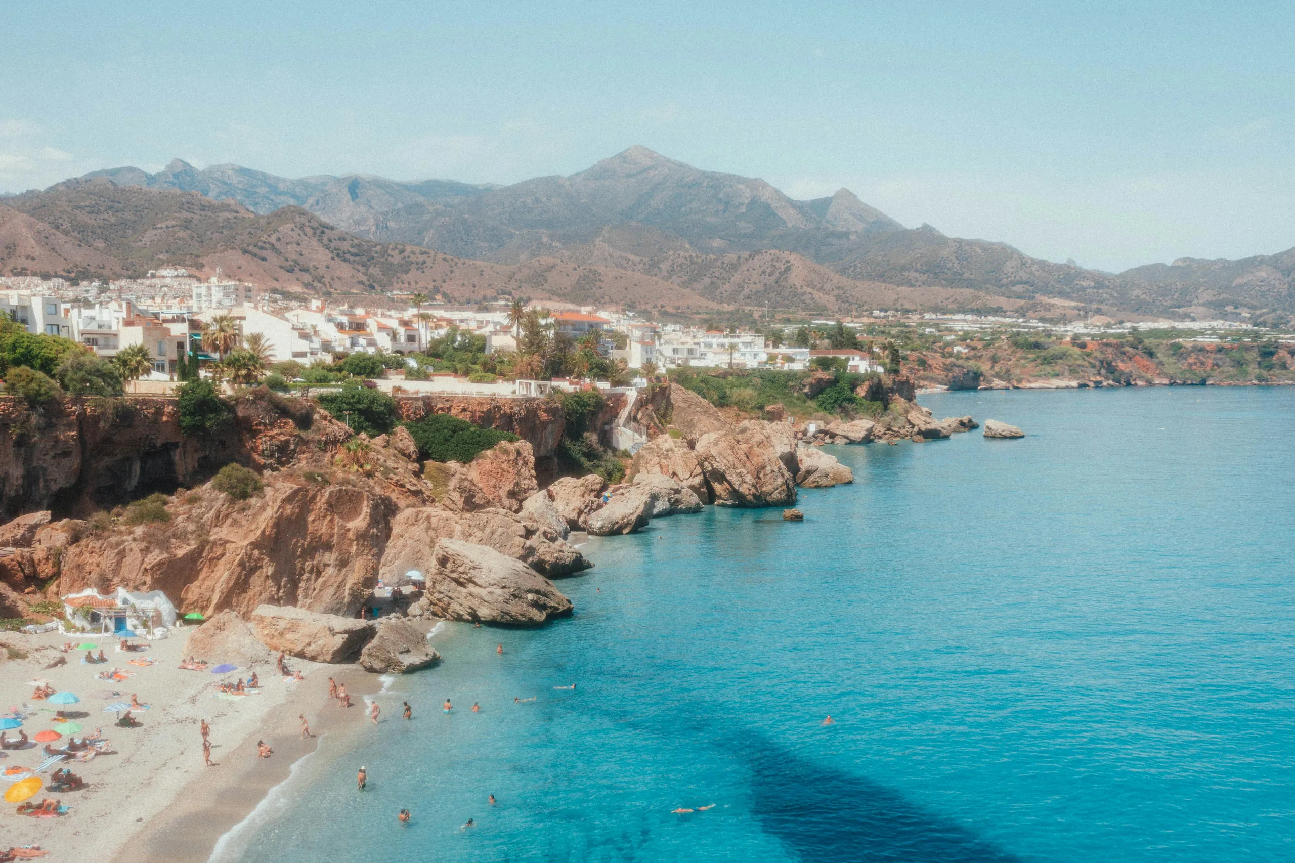 Cove with swimmers below the white town of Nerja near Torrox – Torrox